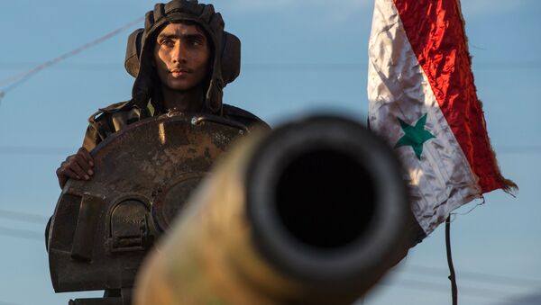 Soldados sírios sobre um veículo autopropulsado de artilharia na fronteira turco-síria perto de cidade de Kesab, Síria, 10 de fevereiro de 2016 - Sputnik Brasil