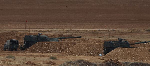 Turkish soldiers hold their positions with their artillery pieces, bottom, on a hilltop in the outskirts of Suruc, at the Turkey-Syria border, overlooking Kobani, Syria, background, during fighting between Syrian Kurds and the militants of Islamic State group, Thursday, Oct. 16, 2014 - Sputnik Brasil