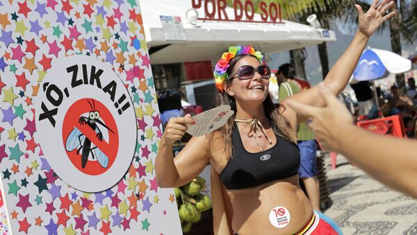 Viviane Oliveira, who's three months pregnant, dances next to a sign that reads in Portuguese : Get out Zika during a street carnival on Ipanema beach in Rio de Janeiro, Brazil, Sunday, Jan. 31, 2016 - Sputnik Brasil