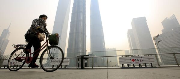 Mulher anda de bicicleta e cobre o rosto para se proteger da poluição em Pudong - Sputnik Brasil