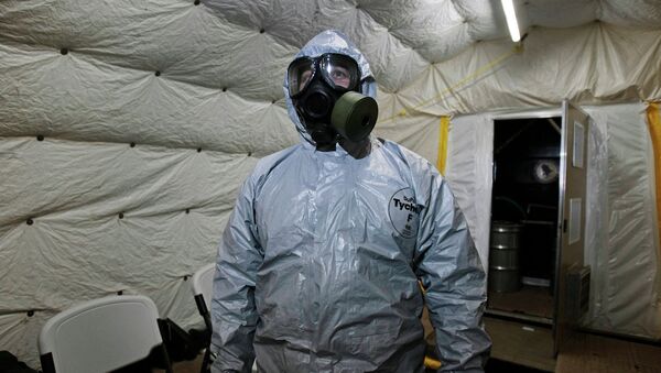 Especialista mostra a jornalistas as roupas especiais utilizadas durante a neutralização de armas químicas - Sputnik Brasil
