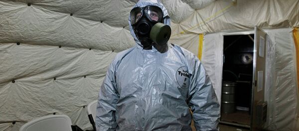 Especialista mostra a jornalistas as roupas especiais utilizadas durante a neutralização de armas químicas - Sputnik Brasil