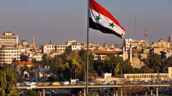 Bandeira síria esvoaçando enquanto os carros seguem por ponte durante a hora de ponta, Damasco, Síria, 28 de fevereiro de 2016 - Sputnik Brasil