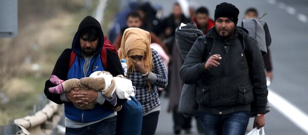 Refugees carry their children through a national motorway towards the Greek-Macedonian border near the Greek town of Polykastro. - Sputnik Brasil