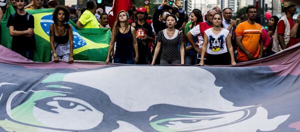 Manifestantes expõem um cartaz com a imagem da presidente Dilma Rousseff - Sputnik Brasil