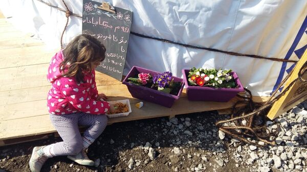 Pequena refugiada toma almoço perto da escola no campo de refugiados Linière, Grande-Synthe, França - Sputnik Brasil