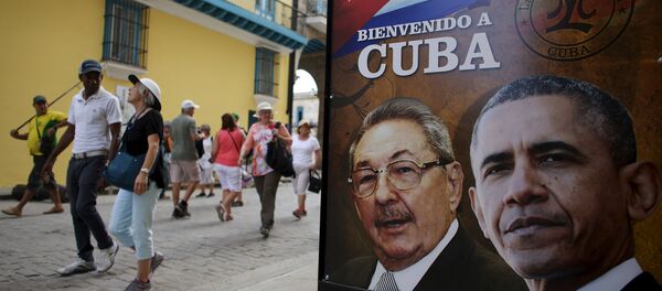 Tourists pass by images of U.S. President Barack Obama and Cuban President Raul Castro in a banner that reads Welcome to Cuba at the entrance of a restaurant in downtown Havana, March 17, 2016. - Sputnik Brasil
