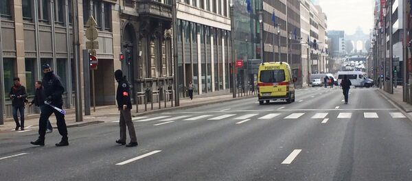 Policiais belgas e veículos de serviços de emergência na rua onde fica a entrada para a estação de metrô de Maelbeek, Bruxelas, Bélgica, 22 de março de 2016 - Sputnik Brasil
