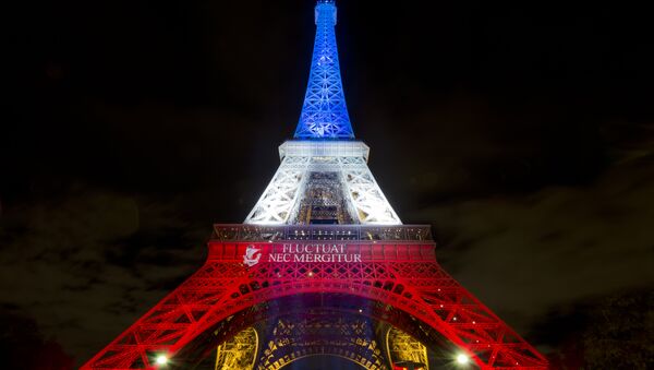 A photo taken on November 17, 2015 in Paris shows the Eiffel Tower illuminated with the colors of the French national flag in tribute to the victims of the November 13 Paris terror attacks. - Sputnik Brasil