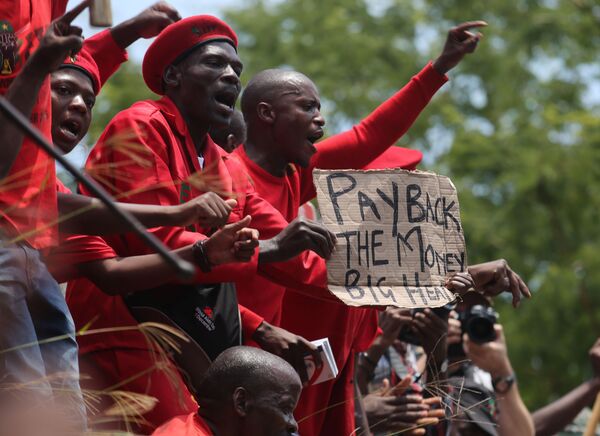 Em 9 de fevereiro de 2016, membros da organização não governamental Economic Freedom Fighters protestaram contra a reforma em Nkandla. O cartaz mostrado na foto diz: Pague o dinheiro de volta, grande frango! - Sputnik Brasil