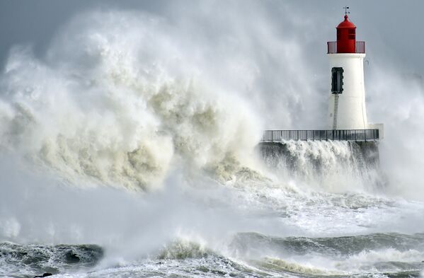 Ondas rebentando contra o farol na cidade portuária de Les Sables-d'Olonne, França - Sputnik Brasil