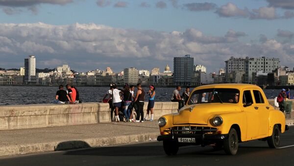 Youth sit on Havana's El Malecon seafront bolulevard December 17, 2014. - Sputnik Brasil
