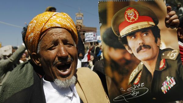 Um homem grita palavras de ordem mostrando um cartaz com a imagem do ex-presidente iemenita Ali Abdullah Saleh durante uma manifestação em 7 de novembro de 2014 - Sputnik Brasil