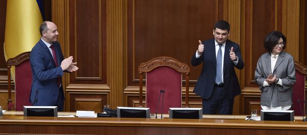 O novo primeiro-ministro da Ucrânia, Vladimir Groisman, no centro da foto, saúda os deputados depois da sua nomeação, em 14 de abril de 2016. Ao lado dele, está Oksana Syroed, vice-presidente do parlamento ucraniano. À esquerda na foto, o presidente do parlamento, Andrei Parubiy - Sputnik Brasil