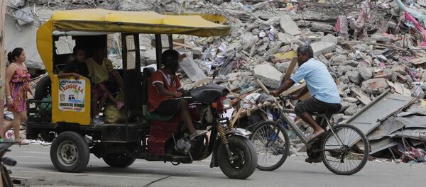 Moradores vão em bicicleta, carro improvisado e a pé pela cidade de Pedernales, Equador, completamente destruída pelo terremoto de 16 de abril. - Sputnik Brasil