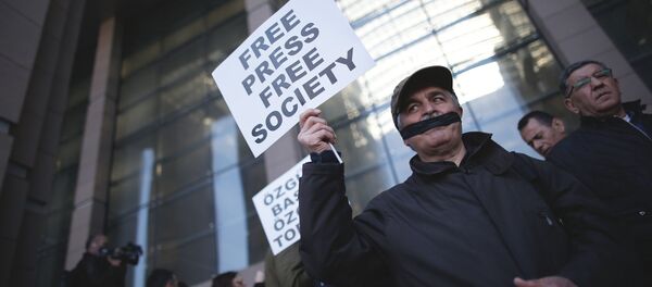 Turkish journalists cover their mouths with black ribbons before the trial of Can Dundar, the editor-in-chief of opposition newspaper Cumhuriyet and Erdem Gul, the paper's Ankara representative, outside the courthouse in Istanbul, Friday, April 1, 2016 - Sputnik Brasil