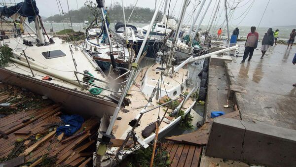 Local residents look at damaged boats against a jetty in Port Vila, the capital city of the Pacific island nation of Vanuatu March 14, 2015 - Sputnik Brasil