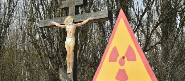 A placa indica perigo radioativo ao lado de cricifixo perto da usina nuclear de Chernobyl A placa indica perigo radioativo ao lado de cricifixo perto da usina nuclear de Chernobyl - Sputnik Brasil