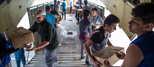 Unloading Russian EMERCOM plane with humanitarian aid which arrived to Latakia Airport in Syria. File photo - Sputnik Brasil