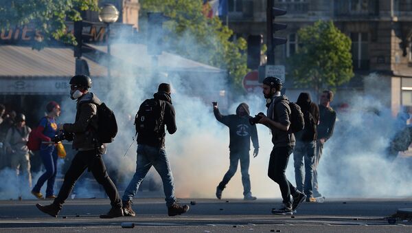 Protesters and photographers stand on the Place de la Nation during clashes with police at a traditional May Day demonstration on May 1, 2016, in Paris. - Sputnik Brasil