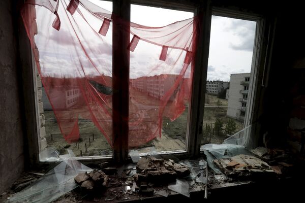 Cortina vermelha perante uma janela quebrada na cidade fantasma de Skrunda-1, Letônia, 9 de abril, 2016 - Sputnik Brasil