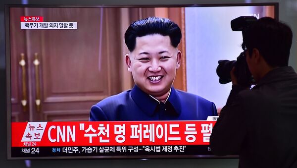 Homem tira uma foto da tela com a imagem do líder norte-coreano Kim Jong-un numa estação ferroviária em Seul, Coreia do Sul, 6 de maio de 2016 - Sputnik Brasil