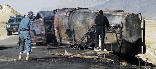 Afghan policemen stand near a burnt out fuel tanker (File) - Sputnik Brasil