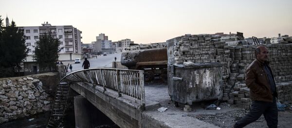 People walk past a burned truck at the entrance of Nusaybin on December 24, 2015, in Mardin People walk past a burned truck at the entrance of Nusaybin on December 24, 2015, in Mardin - Sputnik Brasil
