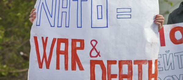 Activistas sosteniendo carteles anti-OTAN - Sputnik Brasil