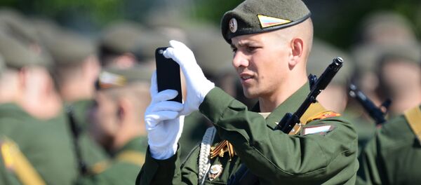 Um soldado fotografa a Parada da Vitória na praça Vermelha em 9 de maio de 2016 - Sputnik Brasil