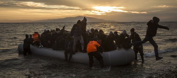 Refugiados e migrantes desembarcam na praia após atravessar o mar Egeu, 2016 - Sputnik Brasil