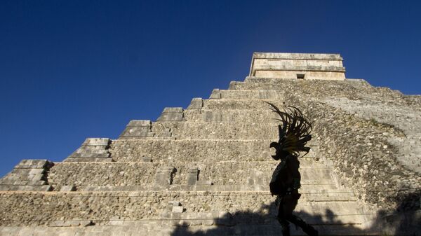 Um homem vestindo hábito maia passa na frente da pirâmide Kukulcan, no parque arqueológico Chichen Itzá, em 20 de dezembro de 2012 - Sputnik Brasil