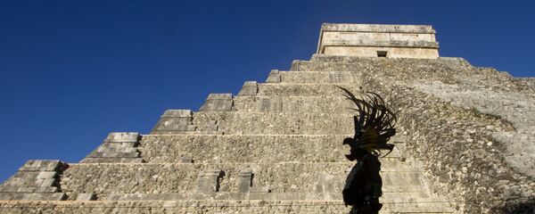 Um homem vestindo hábito maia passa na frente da pirâmide Kukulcan, no parque arqueológico Chichen Itzá, em 20 de dezembro de 2012 - Sputnik Brasil