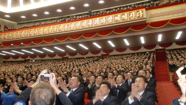 Pessoas presentes na sala do Palácio da Cultura Popular, em Pyongyang, saúdam o líder da Coreia do Norte, Kim Jong-un, na VII Reunião do Partido dos Trabalhadores deste país - Sputnik Brasil