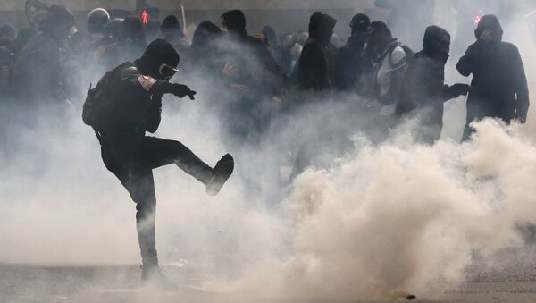 Manifestante chuta granada de gás lacrimogênio de volta para a polícia em protesto contra reforma trabalhista em Paris. - Sputnik Brasil