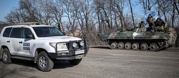 Carro da OSCE em frente a veículo militar ucraniano Carro da OSCE em frente a veículo militar ucraniano - Sputnik Brasil
