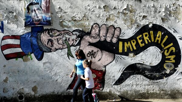 Uma mulher anda com uma menina em frente do grafite do Uncle Sam em Caracas - Sputnik Brasil
