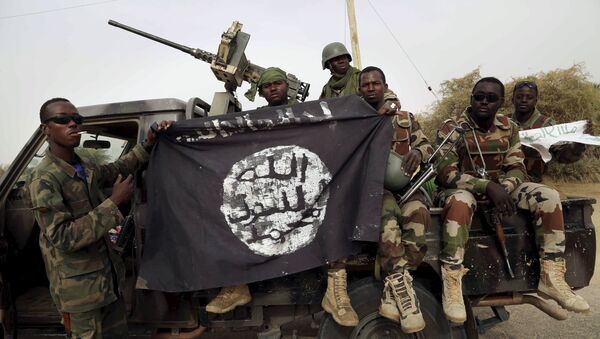 Soldados nigerianos exibem bandeira do Boko Haram apreendida na retomada da cidade de Damasak, em 18 de março de 2015 - Sputnik Brasil