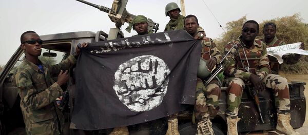 Soldados nigerianos exibem bandeira do Boko Haram apreendida na retomada da cidade de Damasak, em 18 de março de 2015 Soldados nigerianos exibem bandeira do Boko Haram apreendida na retomada da cidade de Damasak, em 18 de março de 2015 - Sputnik Brasil