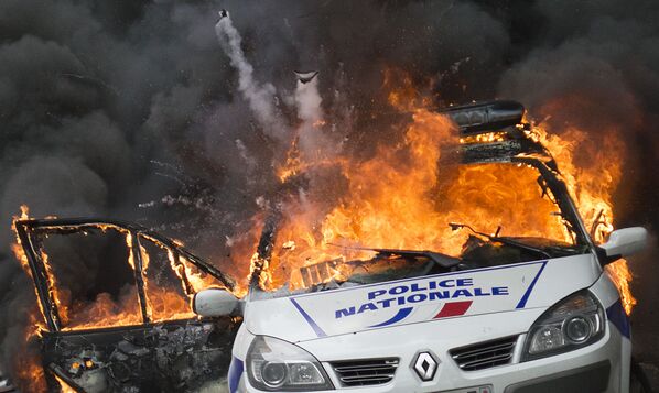 Um carro da polícia arde durante os confrontos em Paris - Sputnik Brasil