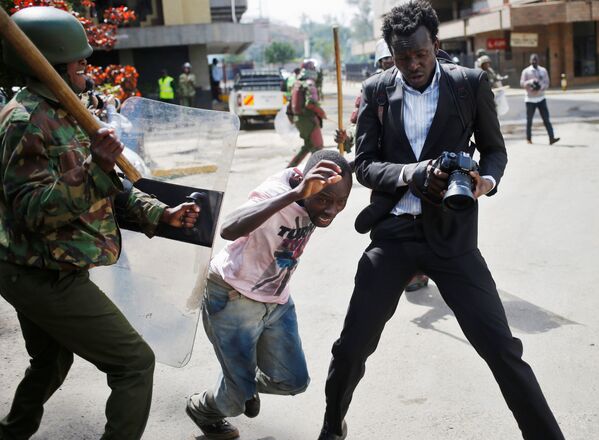 Um policial queniano bate em um manifestante durante confrontos em Nairóbi, Quênia - Sputnik Brasil