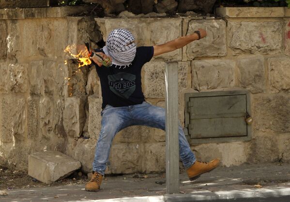 Um palestino atira uma bomba incendiário contra as forças de segurança israelenses durante confrontos - Sputnik Brasil