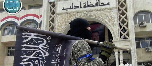 Militante da Frente al-Nusra com a bandeira do grupo na província de Idlib, Síria - Sputnik Brasil