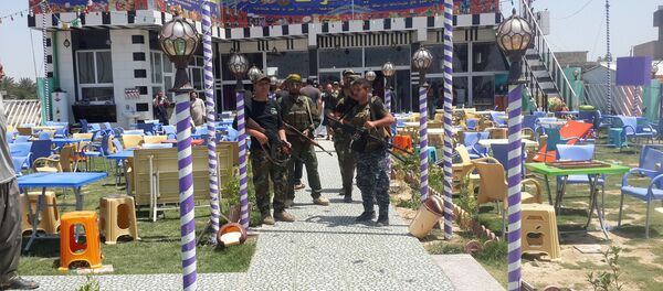 Shi'ite fighters are seen at a cafe where men, including fans of Spain's Real Madrid football club, had gathered, after an attack by gunmen in the predominately Shi'ite Muslim town of Balad, Iraq, May 13, 2016 - Sputnik Brasil