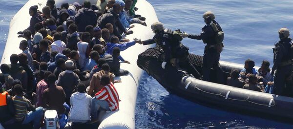 German Navy sailors surround a boat with more than 100 migrants near the German combat supply ship 'Frankfurt am Main' during EUNAVFOR Med, also known as Operation Sophia, in the Mediterranean Sea off the coast of Libya, Tuesday, March 29, 2016 - Sputnik Brasil