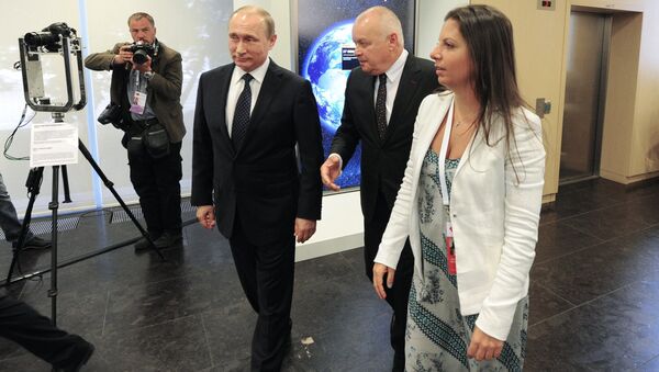 O presidente da Rússia, Vladimir Putin (centro) passeia pela sede da agência internacional de notícias Rossiya Segodnya junto com o diretor-general da mesma, Dmitry Kiselev (segundo da direita) e a editora-chefe da agência e do canal televisivo RT, Margarita Simonyan (direita), em 7 de junho de 2016 - Sputnik Brasil