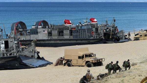 US marines push a Humvee stuck on the sand as they disembark from the overcrafts deploid by the USS Arlington amphibious transport dock during the NATO's Trident Juncture exercise at Pinheiro da Cruz beach, south of Lisbon, near Grandola on October 20, 2015 - Sputnik Brasil