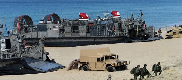 US marines push a Humvee stuck on the sand as they disembark from the overcrafts deploid by the USS Arlington amphibious transport dock during the NATO's Trident Juncture exercise at Pinheiro da Cruz beach, south of Lisbon, near Grandola on October 20, 2015 - Sputnik Brasil