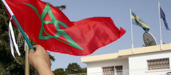 Moroccan woman waves her national flag outside the Swedish Embassy in Rabat, Morocco, as hundreds of protesters stage a protest against Sweden’s diplomatic position on Moroccan-controlled Western Sahara, Sunday, Oct. 4, 2015 - Sputnik Brasil