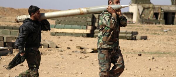 Soldados do exército sírio carregam um missil a ser disparado contra as posições do Daesh em Raqqa - Sputnik Brasil